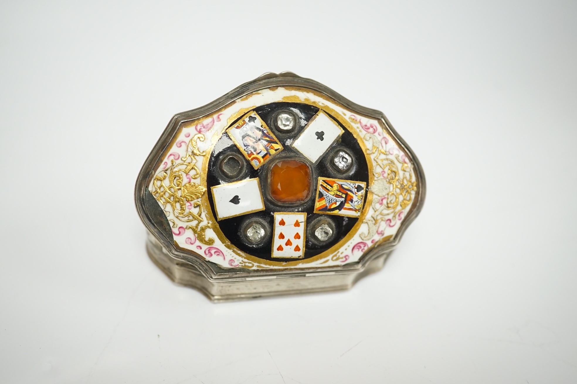 A continental white metal, enamel and two colour paste? set shaped oval snuff box, decorated with playing cards, unmarked, 67mm. Condition - poor